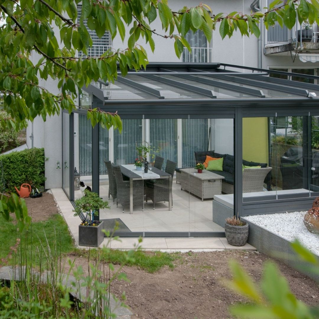 Glasdach Wintergarten in Elsau Zürich mit moderner Einrichtung und Gartenblick
