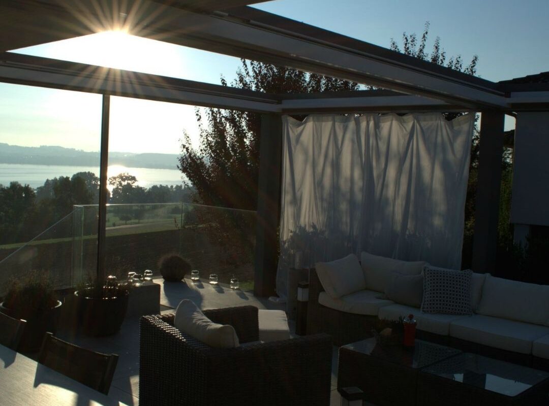 SKL 150 Panorama Lamellendach in Luzern bei Sonnenuntergang mit seitlich geöffneten Lamellen und Blick auf den See