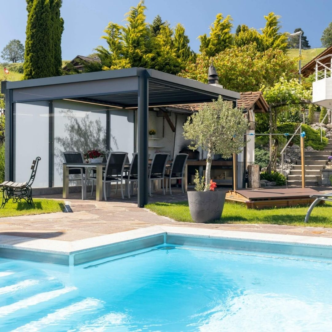 SKL 50 Lamellendach mit geschlossenen Seitenmarkisen neben einem Pool in moderner Gartenanlage.