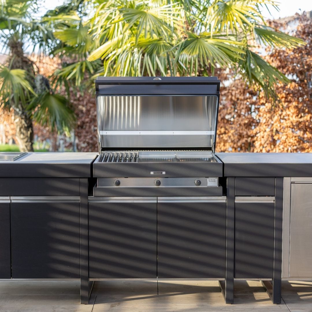 FOGHER Outdoor-Küche mit geöffnetem Grill im modernen Design, eingebaut in eine elegante Küchenzeile im Garten.