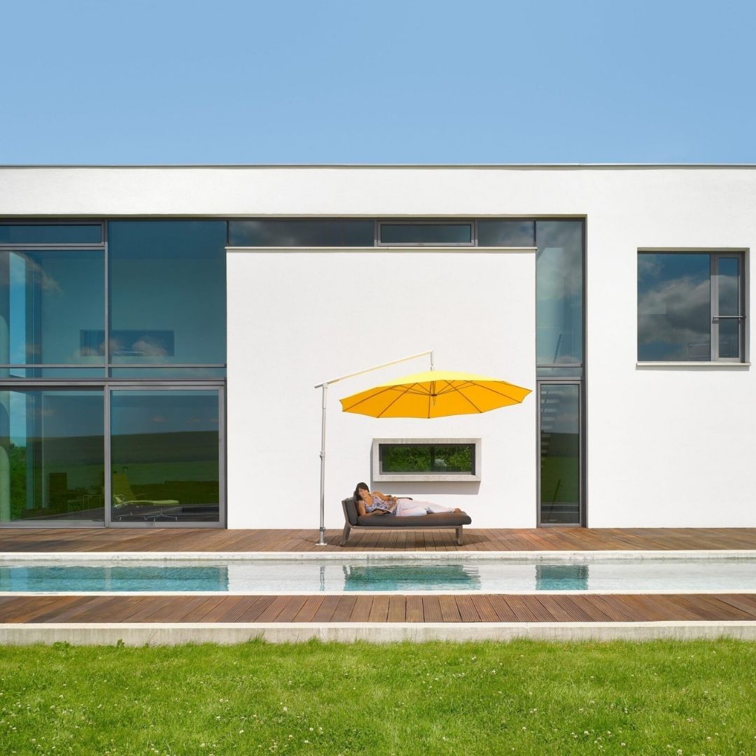 DACAPO Sonnenschirm in Gelb mit seitlichem Mast auf einer modernen Poolterrasse, eleganter und flexibler Sonnenschutz.