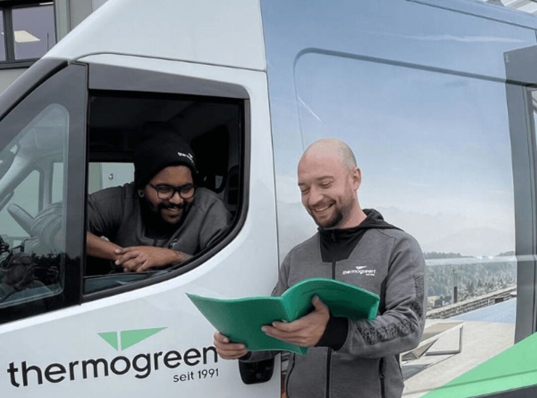 Thermogreen Monteure besprechen die Projektausführung vor Ort neben dem Firmenfahrzeug.
