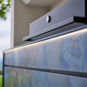 Nahaufnahme einer exklusiven Outdoor Küche mit blauen Fronten und integrierter LED-Beleuchtung.