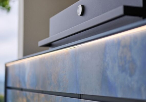 Nahaufnahme einer exklusiven Outdoor Küche mit blauen Fronten und integrierter LED-Beleuchtung.