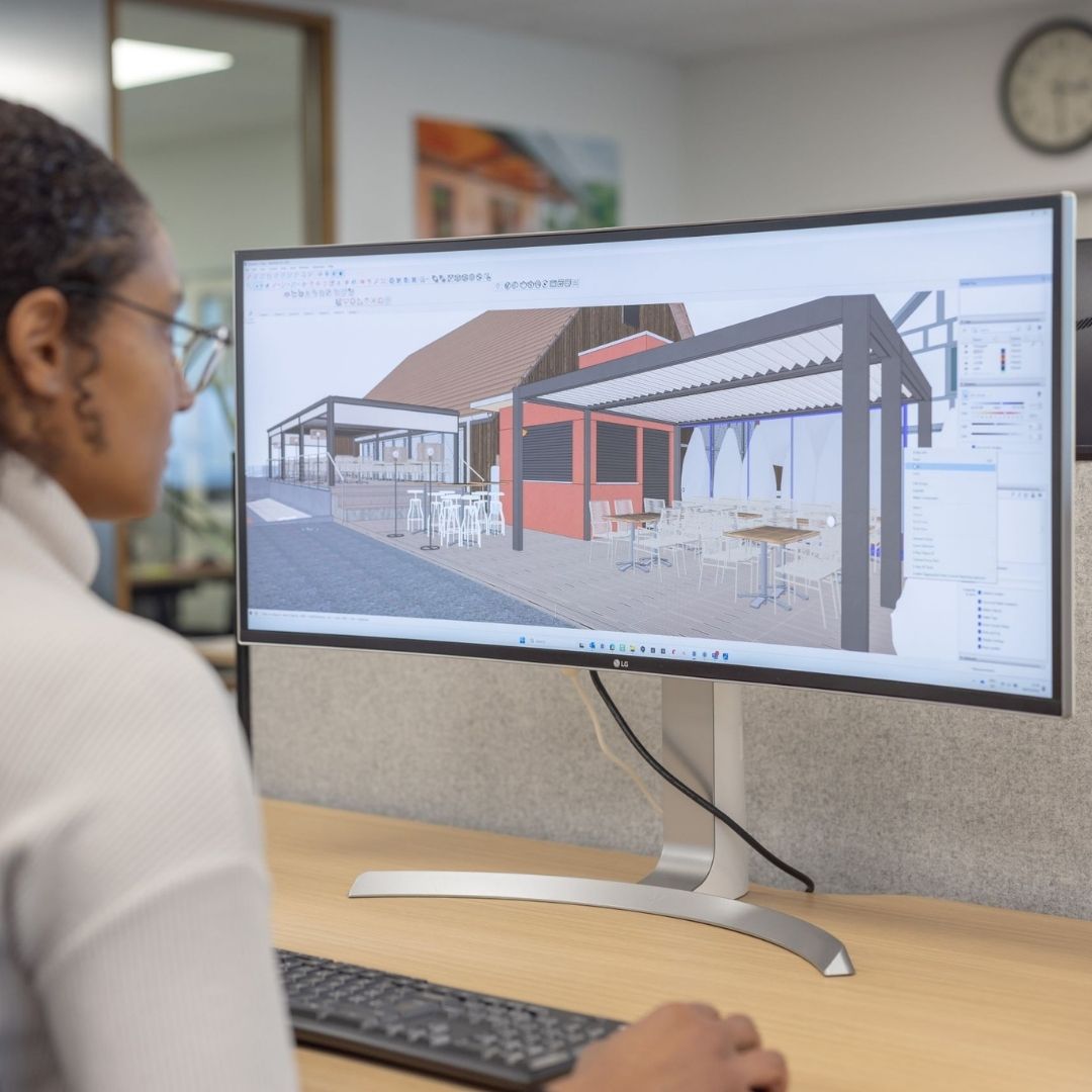 Mitarbeiterin erstellt eine 3D-Visualisierung für die Planung einer Thermogreen Überdachung am Computer.