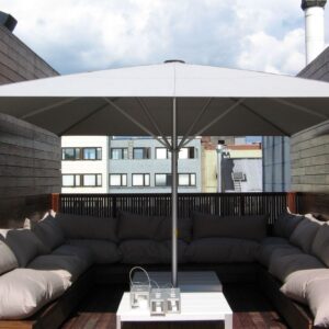 Moderner Sonnenschirm auf einer Dachterrasse mit gemütlicher Lounge und Stadtblick.