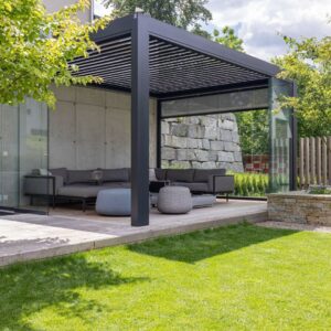 Moderner Aussenbereich mit Lamellendach und Glaswänden, ausgestattet mit einer grosszügigen Lounge auf Holzterrasse.