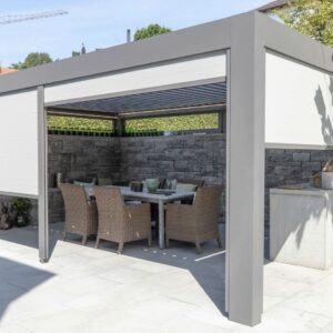 Lamellendach mit integrierten Seitenmarkisen als flexibler Sonnenschutz über einer Terrasse mit Esstisch und Gartenstühlen.