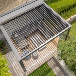 Lamellendach aus der Vogelperspektive mit moderner Lounge darunter, harmonisch in den Garten integriert.