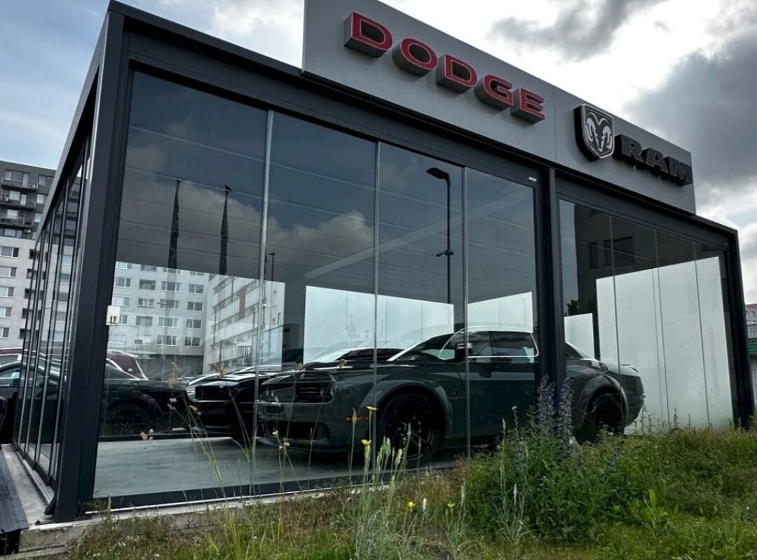 Exklusiver Carport mit Glaswänden für Dodge und RAM Fahrzeuge – modernes Design, Schutz und Premium-Präsentation.