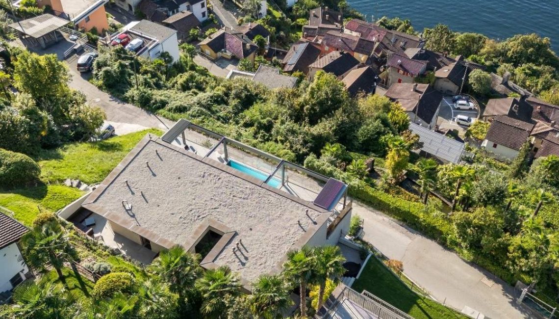Grosszügiges Lamellendach auf der Terrasse eines privaten Wohnhauses in Gerra im Tessin mit Blick auf die umliegende Hügellandschaft und den See.