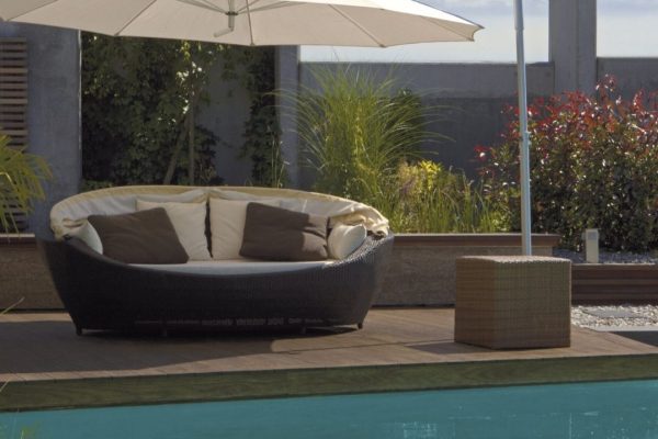 Weisser DACAPO Sonnenschirm mit seitlichem Mast über einer runden Lounge am Pool, eleganter Sonnenschutz mit Bewegungsfreiheit.