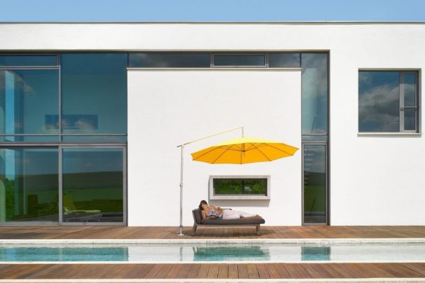 DACAPO Sonnenschirm in Gelb mit seitlichem Mast auf einer modernen Poolterrasse, eleganter und flexibler Sonnenschutz.