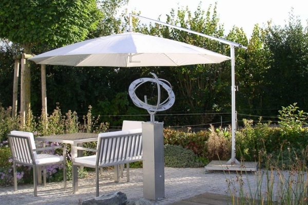 Weisser DACAPO Sonnenschirm mit seitlichem Mast über einem Gartensitzplatz, eleganter und flexibler Sonnenschutz.