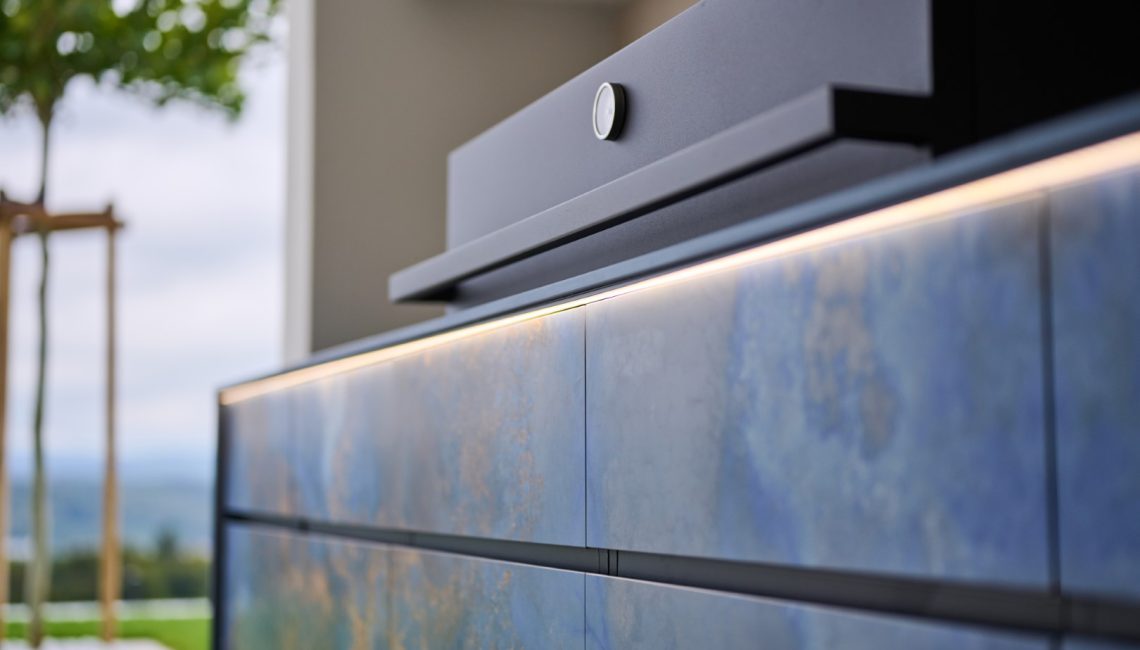 Detail Aussenküche mit strukturierter Keramikfront und indirekter Beleuchtung