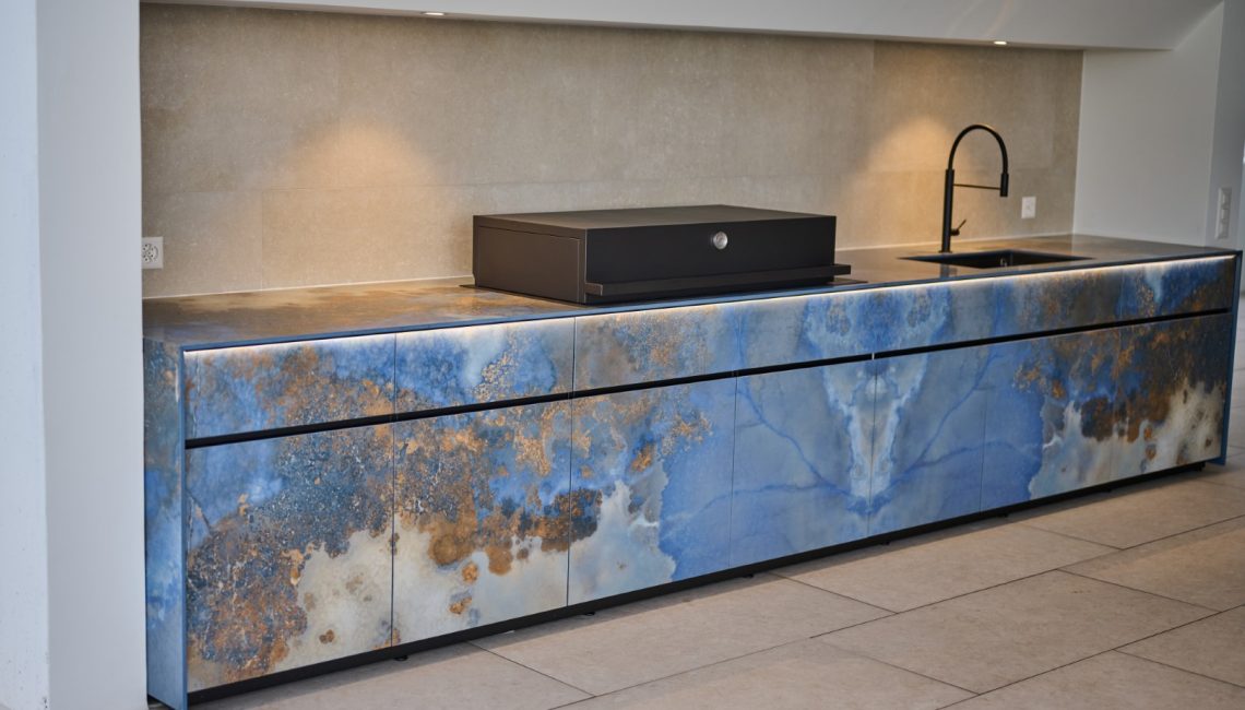 Grosszügige Aussenküche mit strukturierter Keramikfront, Grill und Spülbereich