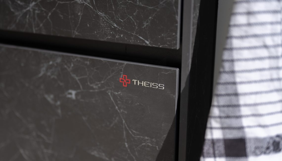 Detailaufnahme der Keramikfront in Nero Greco mit Theiss Logo auf einer hochwertigen Outdoor Küche