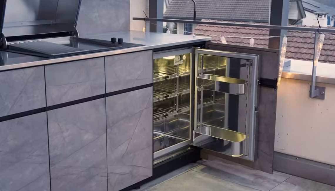 Aussenküche mit geöffnetem Gasherd und integriertem Edelstahl-Kühlschrank
