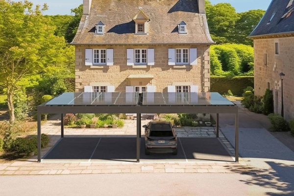 Moderner Doppel-Carport mit Festdach ECL 130 und Solarmodulen vor einem historischen Landhaus, kombiniert Schutz und Nachhaltigkeit.