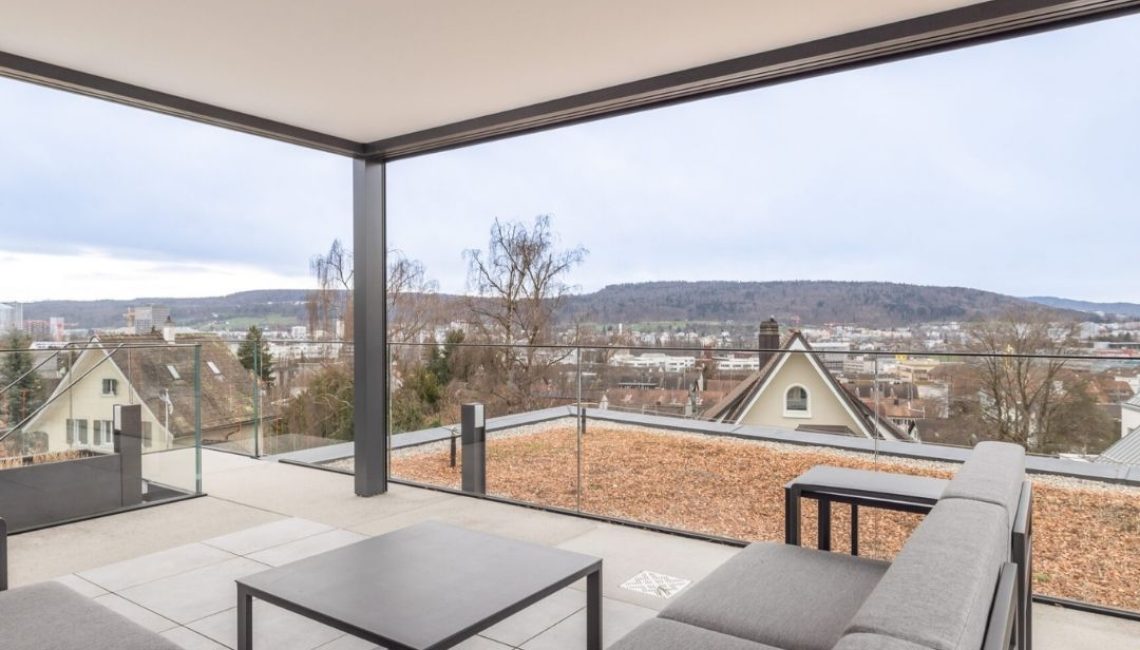 Festdach ECL 130 mit moderner Lounge und Weitblick über Zürich, aufgenommen von der Attikaterrasse eines Einfamilienhauses.