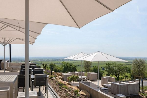 Weisse FILIUS Sonnenschirme auf einer Terrasse mit Panoramablick, eleganter Sonnenschutz für Gastronomie und Hotellerie.