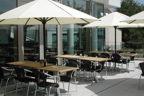 FILIUS Sonnenschirme in heller Ausführung auf einer Restaurantterrasse, langlebiger Sonnenschutz für Gastronomie und Gäste.
