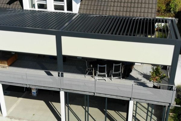 Grossflächiges SKL 140 Lamellendach mit seitlichen Screens, integriert auf einer Terrasse im Obergeschoss eines Einfamilienhauses.