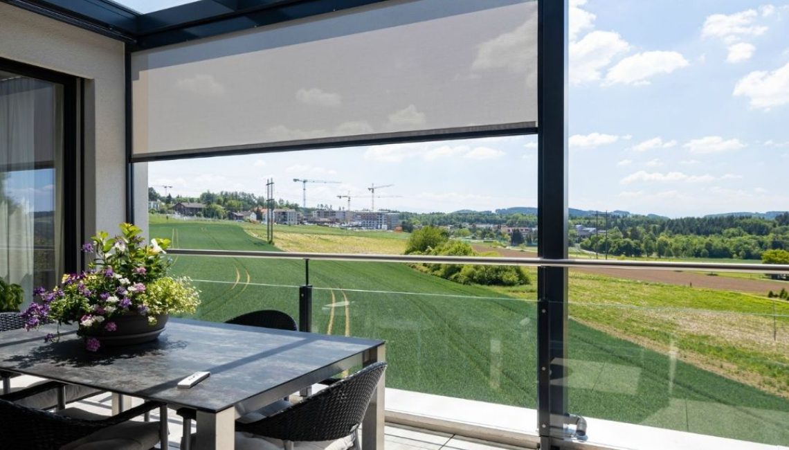 Glasdach mit seitlichem Sonnenschutz in Uitikon Waldegg, Blick auf Felder und Baukräne, moderner Essbereich auf der Terrasse.