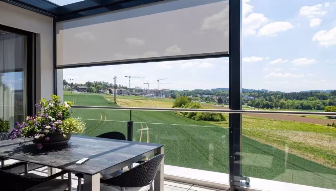 Glasdach mit seitlichem Sonnenschutz in Uitikon Waldegg, Blick auf Felder und Baukräne, moderner Essbereich auf der Terrasse.