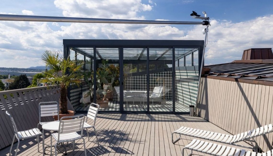 Glasdach-Wintergarten auf dem Dachgarten des Projekts «Kloten-Milano» mit Sitzgelegenheiten und Palmen, ausgelegt für Schneelasten bis 380 kg/m².