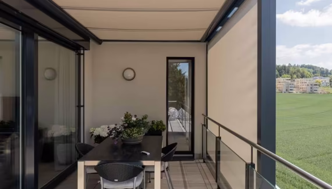 Überdachte Terrasse mit Glasdach und integriertem Sonnenschutz in Uitikon Waldegg, modern eingerichtet mit Esstisch und Stühlen.