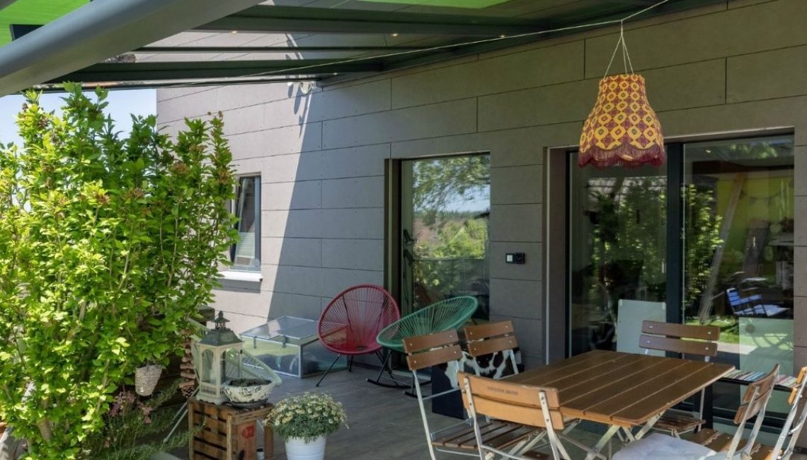 Terrassenbereich unter dem SGL 1 Glasdach in Bachenbülach mit grünem Sonnenschutz und Essplatz