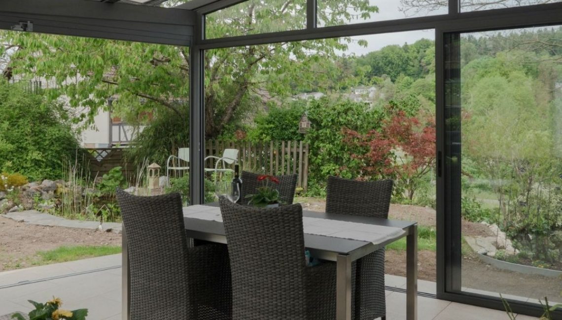 Essbereich unter Glasdach in Elsau Zürich mit grosszügiger Aussicht in den Garten