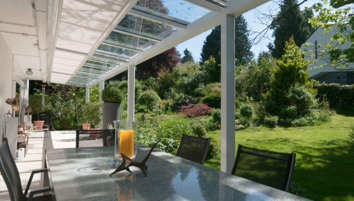 SGL 1 Glasdach im Kanton Luzern mit integriertem Sonnenschutz über einer Terrasse mit Blick in den Garten