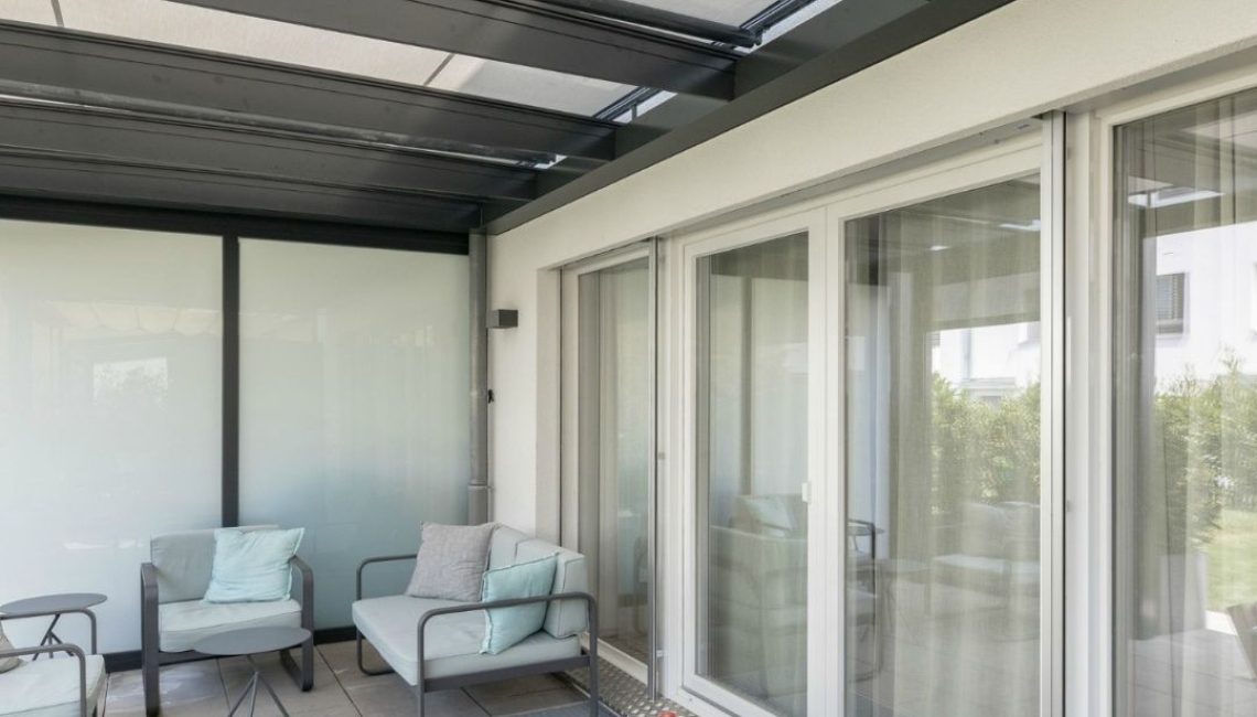 Modernes Glasdach in Ostermundigen mit gemütlicher Sitzlounge, hoher Schneelast bis 380 kg/m² und lichtdurchfluteter Gestaltung.
