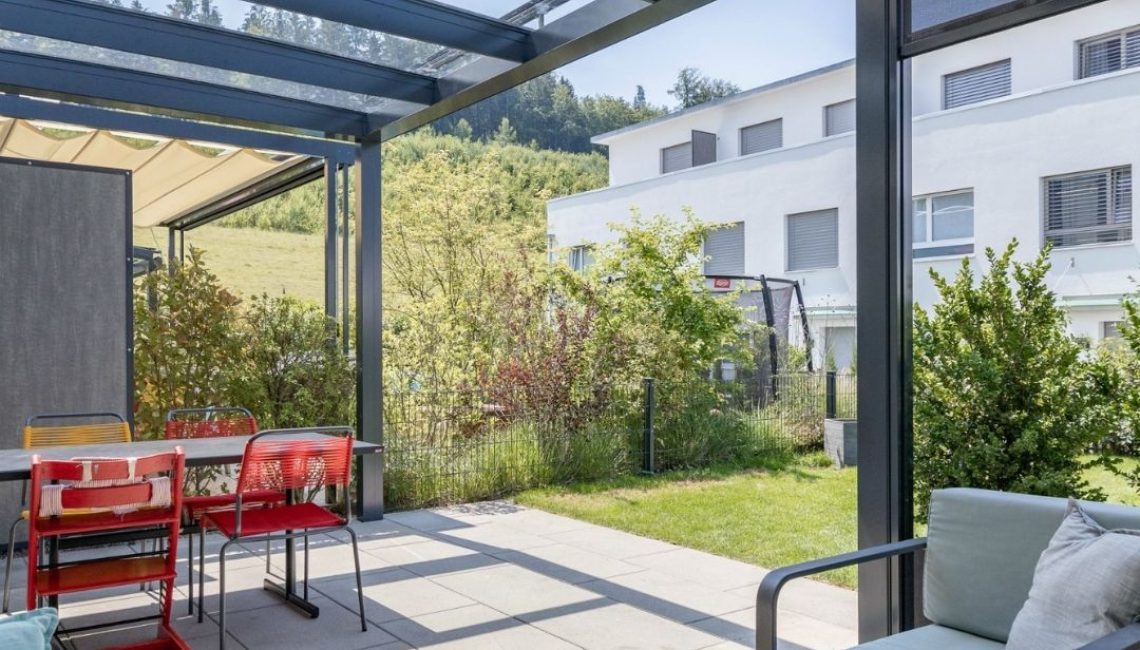 Überdachte Terrasse in Ostermundigen mit modernem Glasdach, das Schutz bietet und eine Schneelast von bis zu 380 kg/m² trägt.