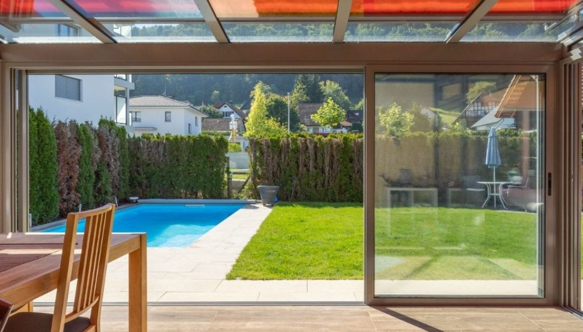Blick vom Wohnbereich durch das SGL 1 Glasdach in Villmergen Aargau auf Pool und Garten