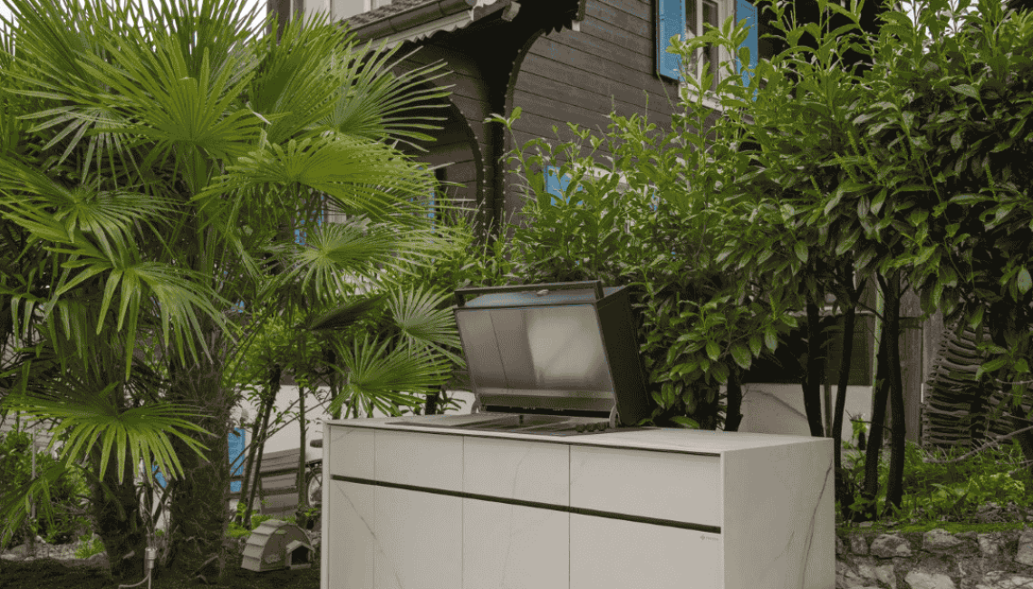 Aussenküche Theiss Avers mit Keramikoberfläche Cristallo Gold und geöffnetem Grillmodul im Garten in Niederwenigen