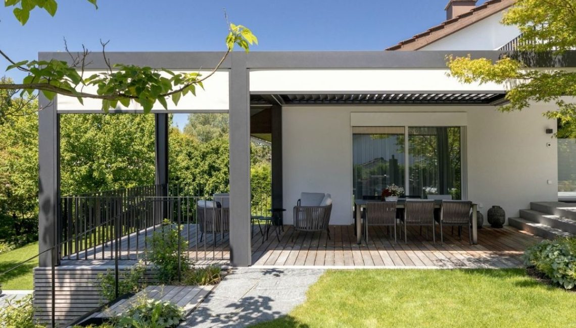 Moderner Sitzplatz mit Lamellendach und Holzterrasse in einem neu gestalteten Privatgarten in Hettlingen.