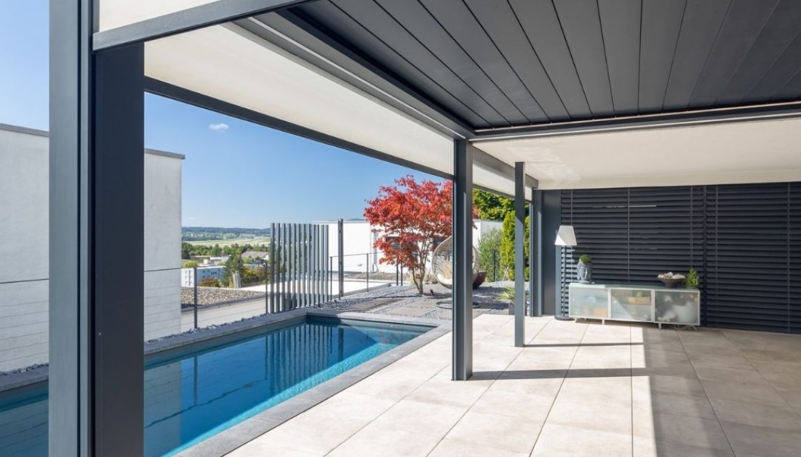 SKL 140 Lamellendach über Poolbereich – moderner Outdoor-Raum mit grosszügiger Überdachung und Blick ins Grüne.