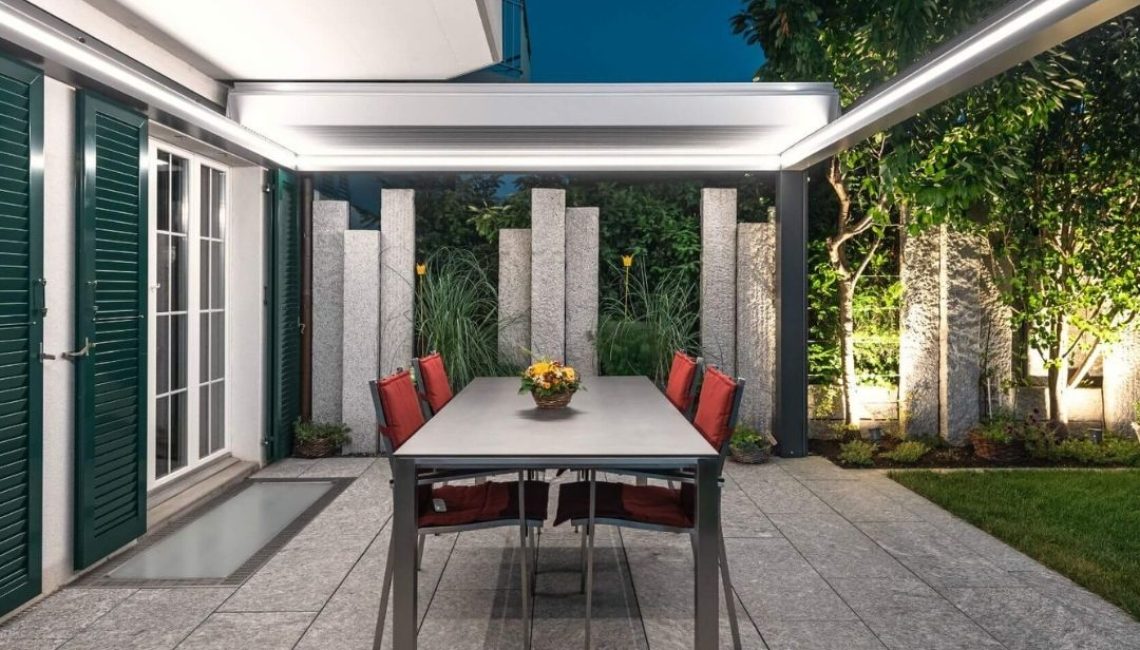 SKL 150+ Panorama Lamellendach in Niederweningen Zürich mit LED-Beleuchtung am Abend, eleganter Essbereich auf der Terrasse.