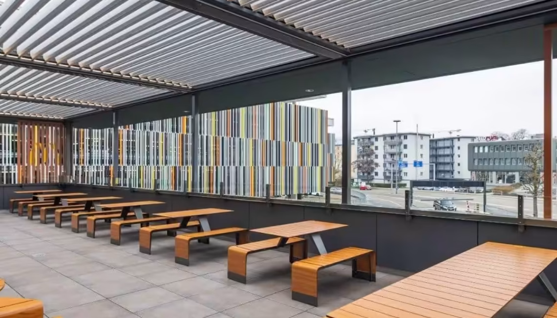 Modernes Lamellendach bei McDonald’s in Emmen, Luzern mit stilvollen Holzbänken und grosszügigem Aussenbereich gemäss Corporate Identity.