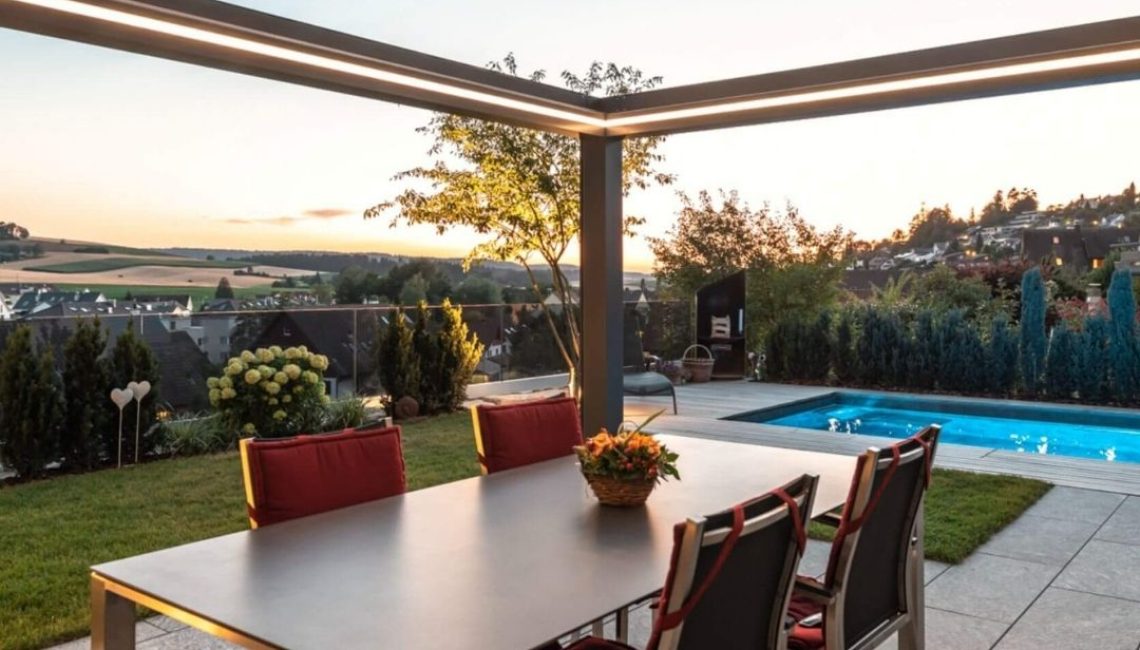 SKL 150+ Panorama Lamellendach in Niederweningen Zürich mit LED-Beleuchtung und Blick auf den Pool bei Sonnenuntergang.