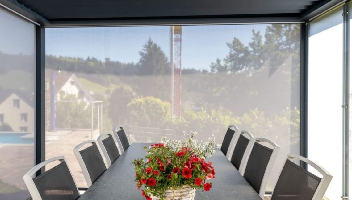 Essbereich unter einem Lamellendach in Eggersriet St. Gallen mit Sichtschutz und grossem Tisch.