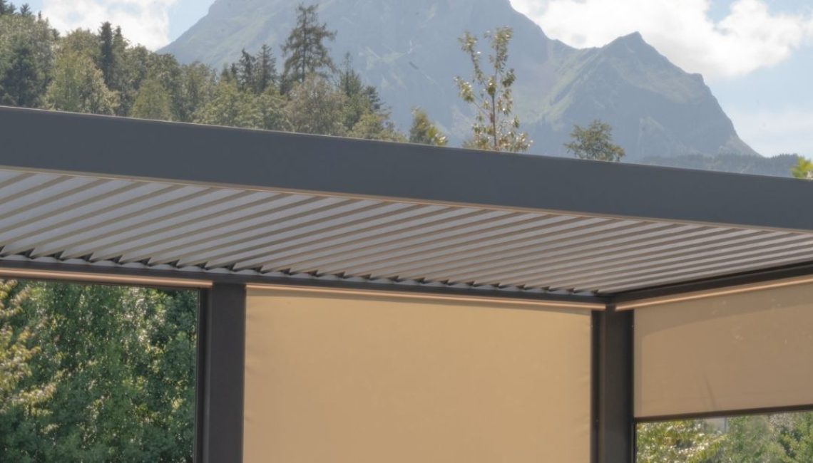 Lamellendach beim Tennisclub Horw in Luzern – überdachter Sitzbereich mit langen Tischen und geschlossenen Senkrechtmarkisen vor Bergkulisse.