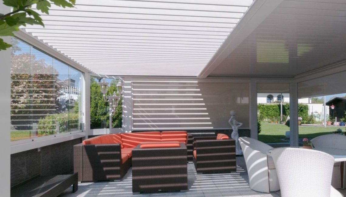 Grosszügiger Outdoor-Wohnbereich unter einem SKL 100 Lamellendach mit Glaswänden und eleganter Lounge in Root, Luzern.