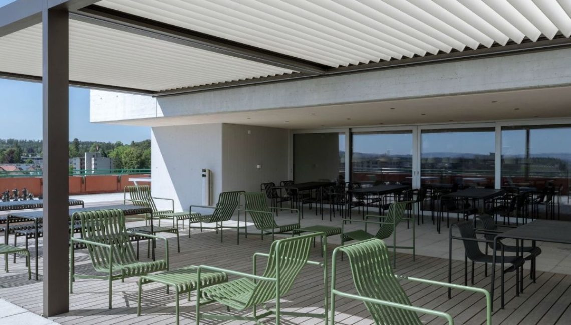SKL 100 Lamellendach auf Terrasse mit grünen Loungestühlen in Aarau