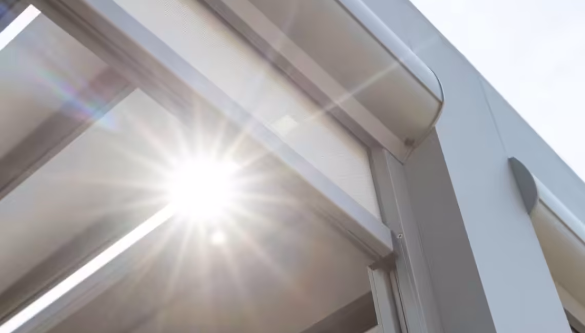 Nahaufnahme der Aluminium-Lamellen eines SKL 140 Lamellendachs in Glattbrugg Zürich mit Sonneneinstrahlung.
