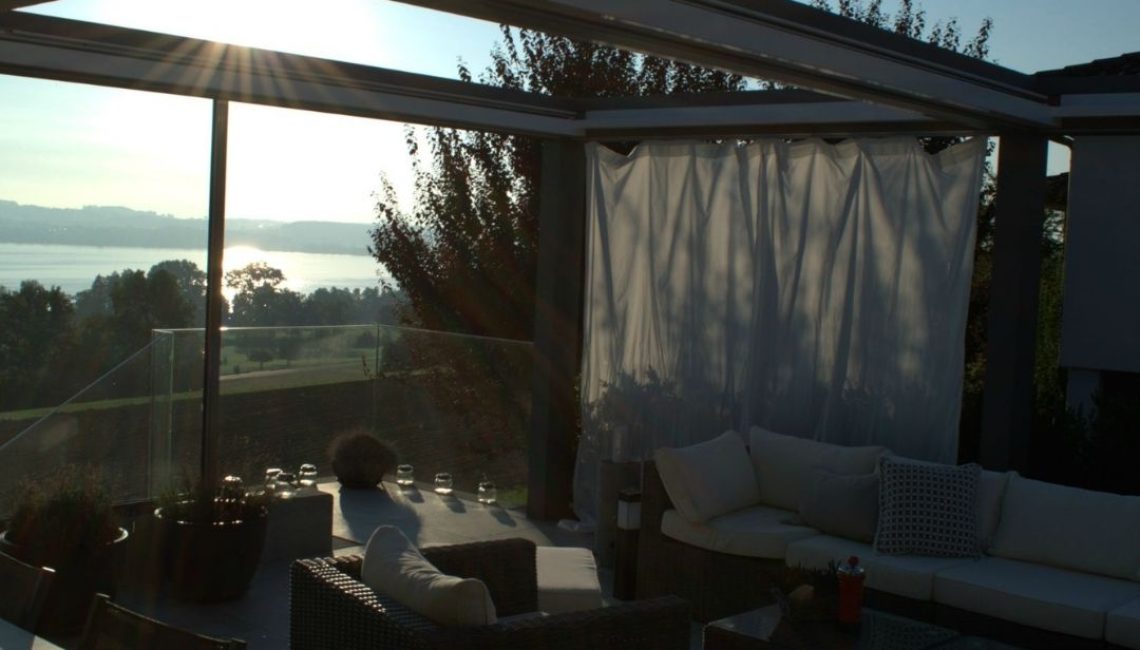 SKL 150 Panorama Lamellendach in Luzern bei Sonnenuntergang mit seitlich geöffneten Lamellen und Blick auf den See