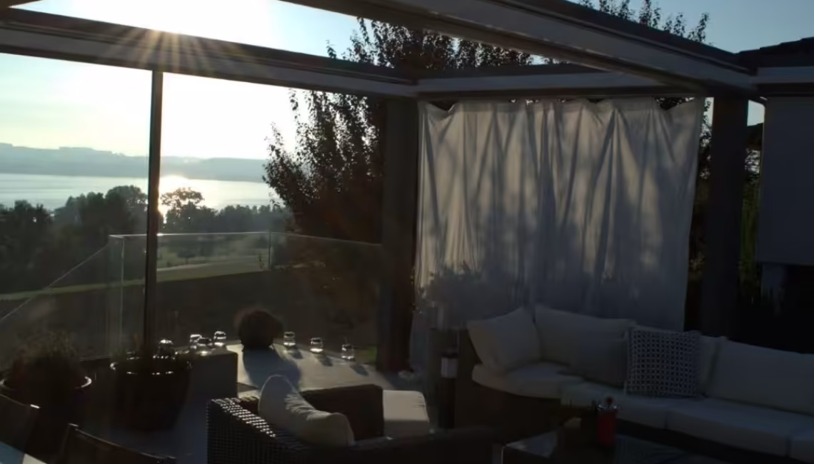 SKL 150 Panorama Lamellendach in Luzern bei Sonnenuntergang mit seitlich geöffneten Lamellen und Blick auf den See
